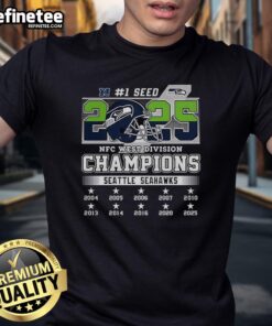 Alt Text: Official Seattle Seahawks NFC West Champions 2025-2026 Seed 1 helmet logo on a stylish t-shirt design.