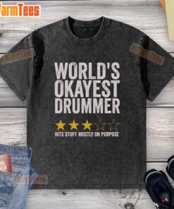 Official World's Okayest Drummer Hits Stuff Mostly On Purpose washed t-shirt displayed on a wooden background.