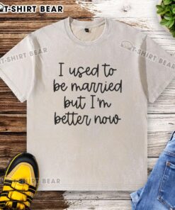 Original 'I Used to Be Married But I'm Better Now' washed t-shirt displayed on a wooden background, showcasing its design.
