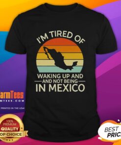 Alt Text: Retro 'I'M Tired Of Waking Up And Not Being In Mexico' sunset t-shirt design featuring vibrant colors and a beach vibe.