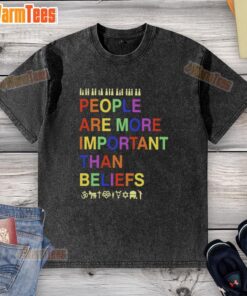 Original People Are More Important Than Beliefs washed t-shirt displayed on a wooden background, showcasing its unique design.