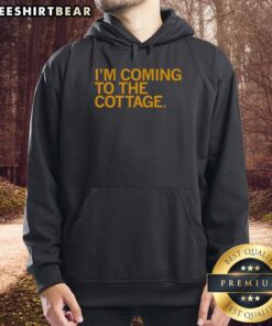 Cozy Premium Im Coming to the Cottage Hoodie displayed on a rustic wooden background, perfect for casual outings.