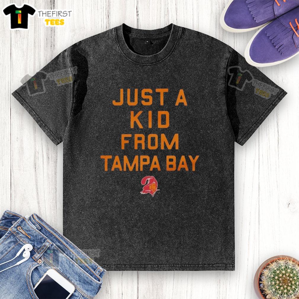 premium-tampa-bay-buccaneers-just-a-kid-from-tampa-bay-washed-t-shirt Alt Text: Premium Tampa Bay Buccaneers Just A Kid From Tampa Bay washed t-shirt displayed on a wooden background.