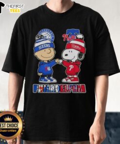 Pretty Charlie Brown fist bump with Snoopy on a Philadelphia 76ers and Phillies T-shirt, perfect for city sports fans.