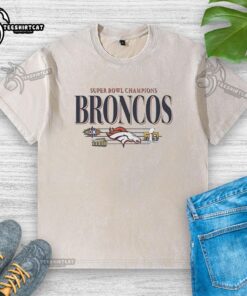 Alt Text: Vintage washed t-shirt featuring Denver Broncos Super Bowl Champions XXII and XXIII graphics in vibrant colors.