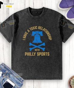 Top I Have A Toxic Relationship With Philly Sports washed t-shirt displayed on a wooden background, showcasing its unique design.