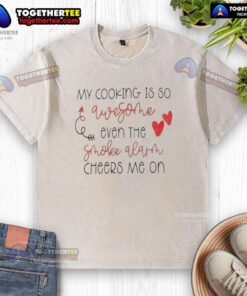 Alt Text: Funny washed t-shirt featuring 'My Cooking Is So Qwesothe Even The Smoke Alarm Cheers Me On' slogan.