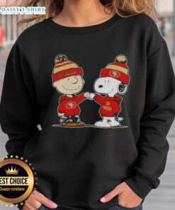 Charlie Brown and Snoopy fist bump in a San Francisco 49ers sweatshirt, celebrating friendship and football spirit.