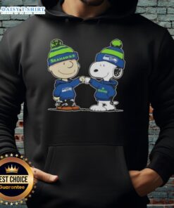 Charlie Brown and Snoopy fist bump in Seattle Seahawks football hoodie, celebrating teamwork and fandom.