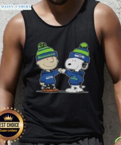 Alt Text: Charlie Brown and Snoopy fist bump in Seahawks gear on a football tank top, celebrating Peanuts fandom.