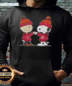 Charlie Brown and Snoopy fist bump in Tampa Bay Buccaneers hoodie featuring top Peanuts characters.