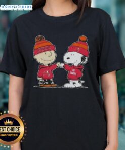 Charlie Brown and Snoopy fist bump on Tampa Bay Buccaneers football ladies tee, perfect for Peanuts fans and sports lovers.