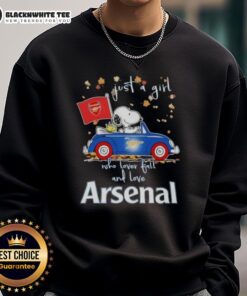 Snoopy driving a car in 'Just a Girl Who Loves Fall' sweatshirt, showcasing Peanuts and Arsenal FC spirit.