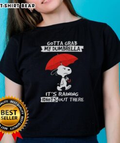 Alt Text: Ladies tee featuring Snoopy with 'Gotta Grab My Dumbrella, It's Raining Idiots Out There' design in vibrant colors.
