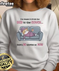 Alt Text: Cozy cat wearing 'I've Made It From The Bed To The Couch' sweatshirt, showcasing a relaxed vibe and humor.