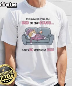 Top tired cat wearing 'I've made it from the bed to the couch, there's no stopping me now' T-shirt, lounging comfortably.