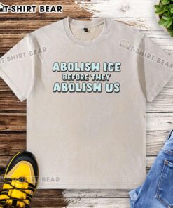 Hot Abolish ICE Before They Abolish Us washed t-shirt featuring bold protest slogan in stylish casual wear.