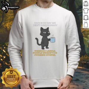 Alt Text: Funny sweatshirt featuring a cat graphic with text about warning labels and common sense, perfect for cat lovers.