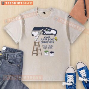 Snoopy and Woodstock drawing on a Seattle Seahawks 2025 Super Bowl Champions t-shirt, celebrating victory.