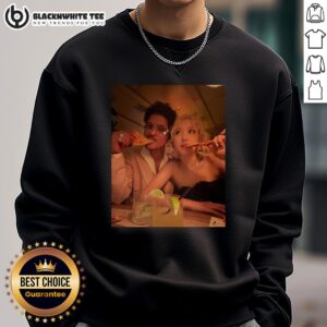 Alt Text: Bruno Mars wearing a stylish sweatshirt featuring a rose while enjoying pizza at the 2026 Grammy Awards.