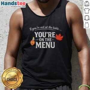 Original 'If You're Not At The Table, You're On The Menu' tank top design featuring bold typography and vibrant colors.