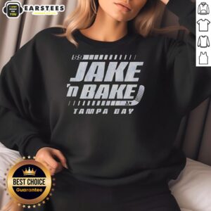 Jake Guentzel wearing a 'Jake N Bake' Tampa Bay Lightning hockey sweatshirt, showcasing team spirit and style.