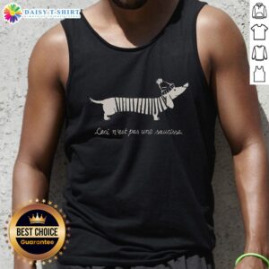 Alt Text: Stylish 'Pretty Ceci Nest Pas Une Saucisse' tank top featuring a playful graphic design on a model outdoors.