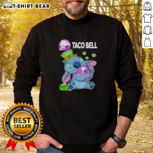 Happy St. Patrick's Day sweatshirt featuring a cute stitch hugging the Taco Bell logo, perfect for festive celebrations.
