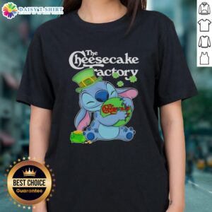 Alt Text: Cute Stitch hugging The Cheesecake Factory logo on a Happy St. Patrick's Day ladies tee design.