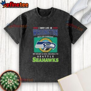 Official I May Live In Washington But On Gameday My Heart Soul Belongs To Seahawks washed t-shirt displayed on a hanger.