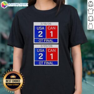 Scoreboard showing USA 2, Canada 1 in overtime final of 2026 women's hockey match on a ladies tee shirt.