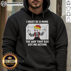 Woman wearing 'Pretty I Must Be A Mime' hoodie, posing playfully inside a large cardboard box, showcasing trendy streetwear.