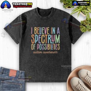 Colorful 'I Believe in a Spectrum of Possibilities' autism awareness text on a washed t-shirt, promoting inclusivity.