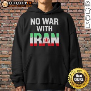 Peace protest featuring a person wearing a 'No War With Iran' hoodie, with the Iranian flag in the background.
