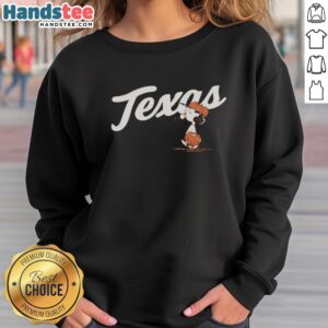 Alt Text: Lucy wearing a Nice Peanuts Texas sweatshirt in the outfield, showcasing a playful and stylish baseball vibe.