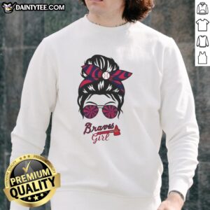 Girl wearing a messy bun and glasses in a cozy Atlanta Braves sweatshirt, showcasing team spirit and casual style.