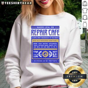 Nice Repair Cafe Makers Local 256 sweatshirt displayed on a wooden table, promoting sustainable repair culture.
