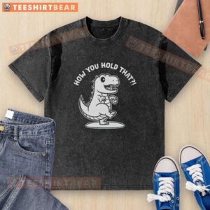 Person holding a washed T-shirt featuring a vibrant T-Rex dinosaur design, perfect for dino enthusiasts.