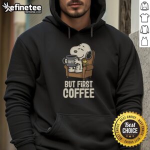 Cozy 'Nice, I Will Have My Coffee First' hoodie displayed on a wooden table with a steaming cup of coffee nearby.