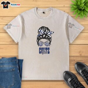 Cheerful Indianapolis Colts girl with a messy bun and glasses, wearing a washed t-shirt, showcasing team spirit.