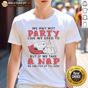 Alt Text: Cute Snoopy t-shirt with the phrase 'We May Not Party Like We Used To But If We Take A Nap' on a fun design.