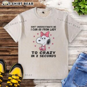 Alt Text: Snoopy graphic on a washed t-shirt with 'Don't Underestimate Me' phrase, showcasing quirky lady-to-crazy humor.