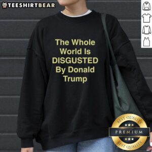 Top-The-Whole-World-Is-Disgusted-By-Donald-Trump sweatshirt featuring bold text design and eye-catching graphics.