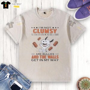 Alt Text: Cute Snoopy 'I'm Not Clumsy, The Floor Just Hates Me' T-Shirt featuring whimsical design with table and chairs