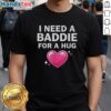 Alt Text: Official I Need A Baddie For A Hug T-Shirt design featuring playful text and stylish graphics on a vibrant background.