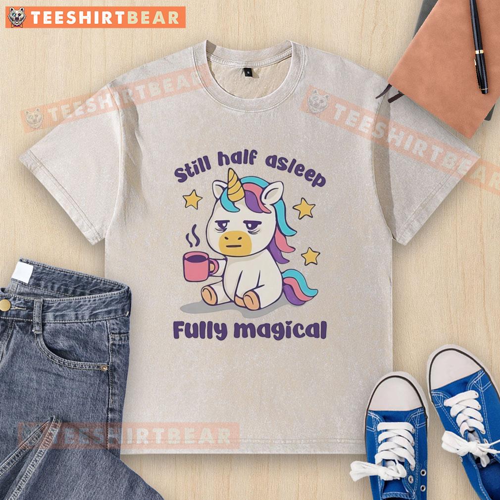 top-unicorn-holding-coffee-mug-still-half-asleep-fully-magical-washed-t-shirt Alt Text: Top unicorn holding a coffee mug, looking still half-asleep in a magical washed t-shirt, perfect for whimsical mornings.
