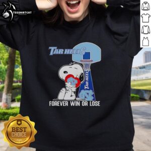 Snoopy holding a heart with 'North Carolina Tar Heels' on a sweatshirt, symbolizing love for the team, win or lose.