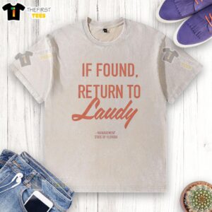 Top If Found Return To Laudy Management Florida washed t-shirt displayed on a wooden background, showcasing casual style.