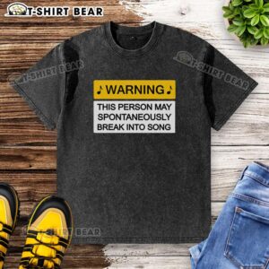 Top warning may break into song washed t-shirt featuring a playful graphic design, perfect for music lovers.