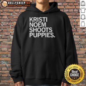 Kristi Noem wearing a hoodie while playfully shooting puppies, showcasing a warm and engaging moment.